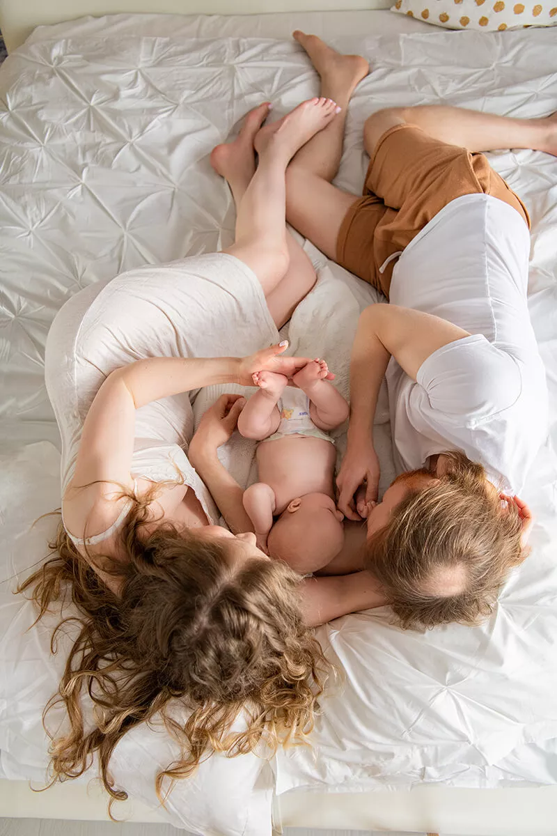 Parents holding their newborn baby during a natural lifestyle session at home
