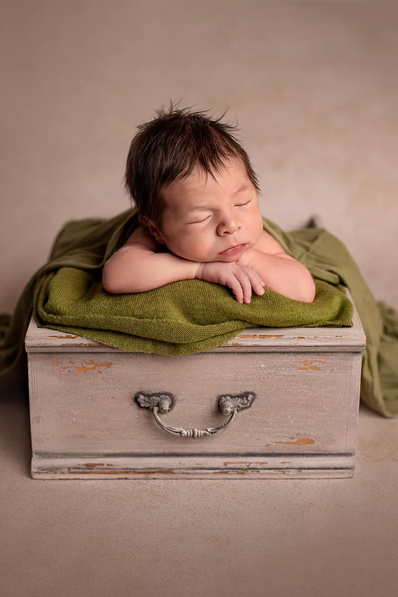 Newborn baby photographed during a premium posed portrait session